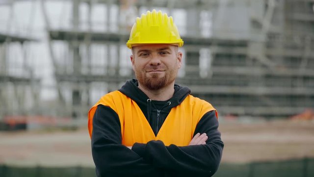 Serious construction worker crosses his arms and stares at the camera