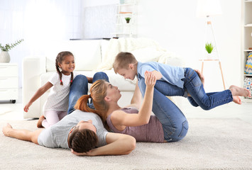 Happy interracial family playing on floor