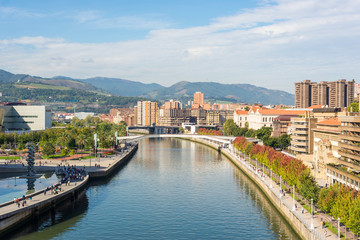 Fototapeta na wymiar View from the famous bridge Salbeko Zubia, to the Deusto and Uribarri districts of Bilbao and the Nervion river that runs through the city into the Cantabrian Sea