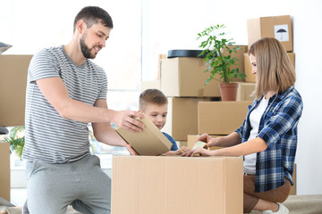 Happy family packing boxes in room.  Moving concept