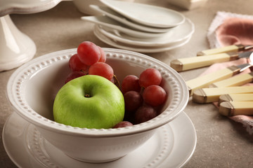 Composition with fresh fruits in white ceramic bowl, close up