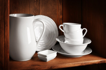 Wooden shelf with white rustic dinnerware