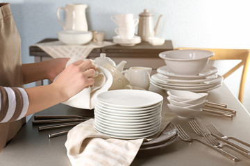 Closeup of female hands cleaning saucer