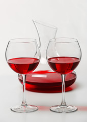 Red wine in glasses and decanter on white background
