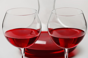 Red wine in glasses and decanter on white background