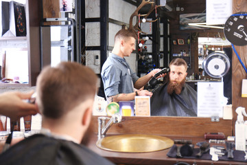 Barber making modern male hairstyle