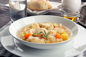 White plate of delicious chicken and dumplings on dining table