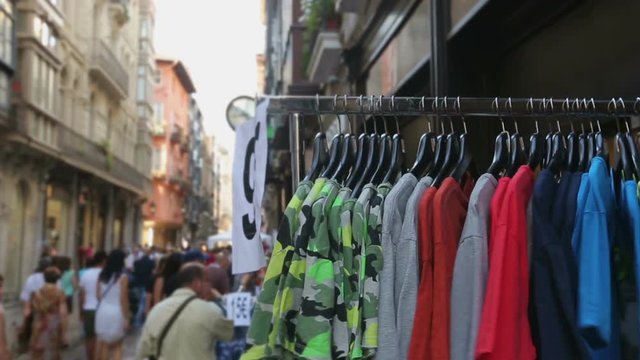 People choosing low priced t-shirts on street shopping stalls at local bazaar