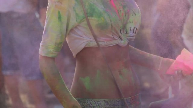 Sexy woman with naked belly shaking powder paint off at Holi festival, holiday