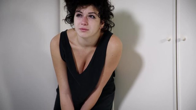 desperate and lonely woman cries leaning cabinet