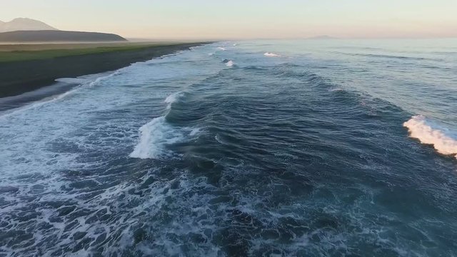 Aerial View. Fast flying along the shore of the ocean. Timelapse.