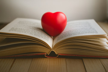 red heart on open book with copy space in relaxation and cozy mood, Image for education, love and brightness  concept