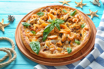 Delicious seafood pizza on turquoise wooden background