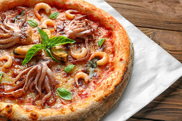 Delicious seafood pizza on cartoon and wooden background