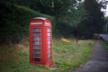 Red telephone booth beside the empty road in Cambridge, England