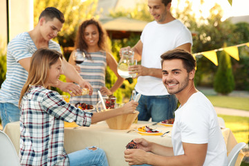 Young friends having barbecue party in garden