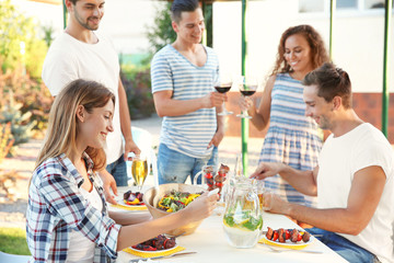 Young friends having barbecue party in garden