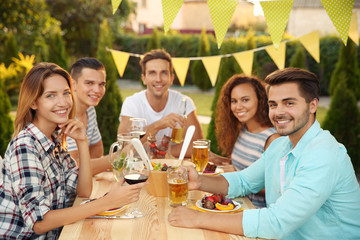 Young friends having barbecue party in garden