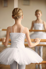 Obraz premium Young beautiful ballerina posing in dance studio