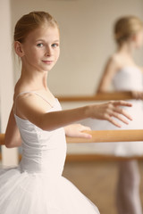 Obraz premium Young beautiful ballerina posing in dance studio