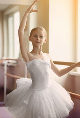 Fototapeta premium Young beautiful ballerina posing in dance studio
