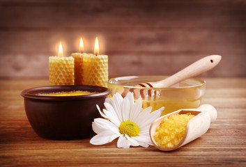 Spa concept. Composition of honey, sea salt and natural wax candles on wooden background