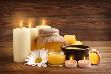 Spa concept. Composition of honey, sea salt and natural wax candles on wooden background