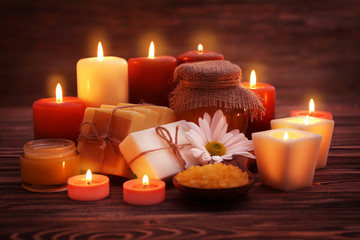 Fototapeta na wymiar Beautiful composition of alight candles and honey treatments on wooden table