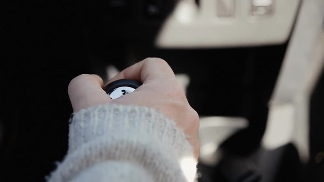The hand of a woman shifting the gearshift from number one to five.
