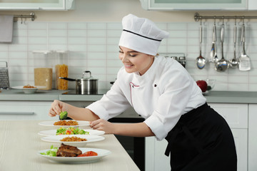 Young woman chef with different dishes on plates in modern kitchen