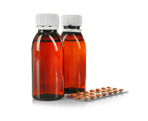 Two bottles of medicine syrup and blister pack with pills isolated on white