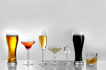 Glasses of wine and spirits on light background