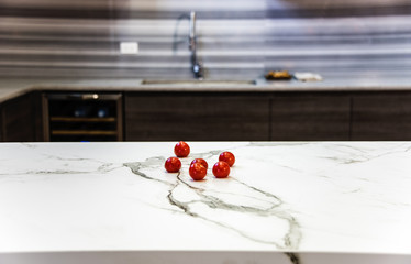 Naklejka na ściany i meble Red tomatoes on white marble kitchen counter, with white netting