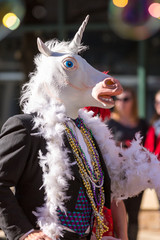 Man Wearing A Suit And Unicorn Mask Walking In Parade