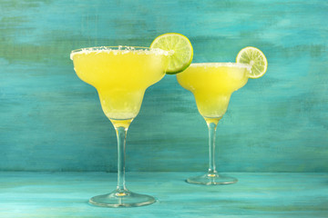 Lemon Margarita cocktails on vibrant turquoise with copyspace
