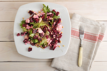 salad with beets, feta, lettuce and pine nuts in a bowl