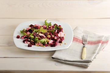 salad with beets, feta, lettuce and pine nuts in a bowl