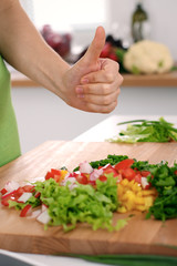 Close up of  woman's hands cooking in the kitchen. Housewife slicing ​​fresh salad. Vegetarian and healthily cooking concept