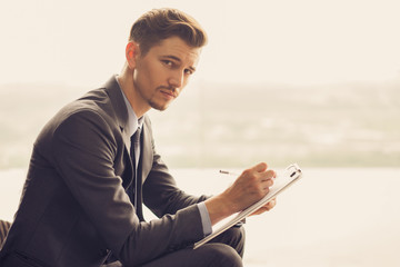 Pensive Look of Writing Middle-aged Businessman