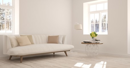 Fototapeta na wymiar White room with sofa and winter landscape in window. Scandinavian interior design
