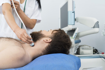 Obraz na płótnie Canvas Patient Undergoing Ultrasound Of Thyroid From Doctor
