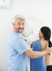 Obraz premium Doctor Assisting Woman Undergoing Mammogram X-ray Test In Hospit