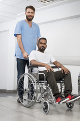 Fototapeta na wymiar Patient Sitting In Wheelchair While Nurse Standing At Hospital