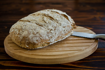 Homemade loaf of bread on wooden table