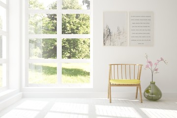 White room with chair and green landscape in window. Scandinavian interior design