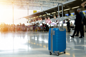 Blue Suitcase in airport terminal.