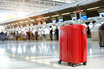 Red Suitcase in airport terminal.