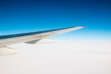 Obraz premium The wing of an airplane flying in the sky