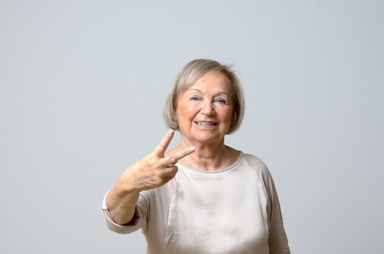 Senior woman showing V signs