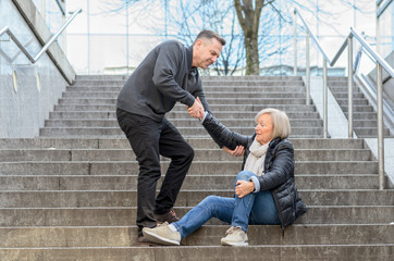 Man helping woman to get up